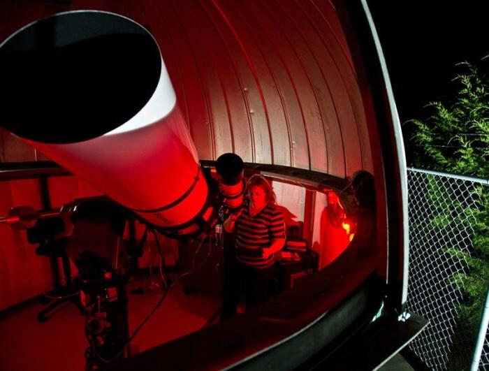 Students viewing stars with giant telescope.