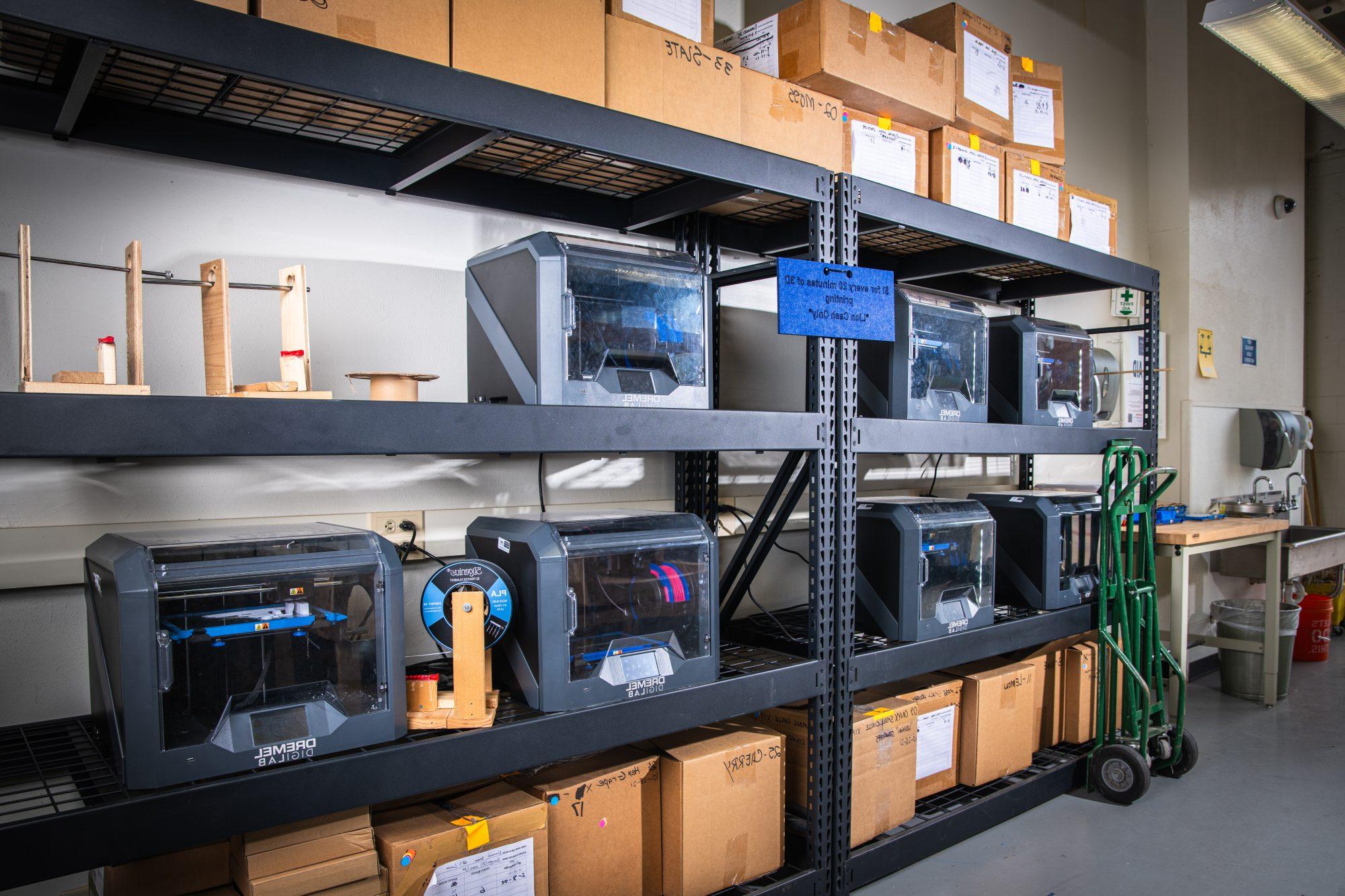 A wall filled with shelves that have boxes and digital lab.